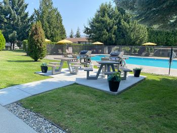 a group of picnic tables in a park next to a pool at Cedarwood, Wenatchee, WA